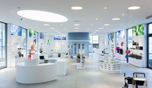 Unterschiedliche Lichtinszenierung durch unterschiedliche Anforderungen im Vital-Zentrum Glotz: Flächenlicht über der Kasse, hinterleuchtete Großfotos, Grundlicht und verstellbare Einbaustrahler zur Akzentuierung der Produkte im lichttechnischen Gesamtkonzept. (Foto: Bettina Matthiessen)