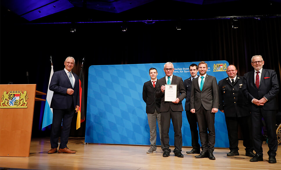 Innenminister Joachim Herrmann verleiht die Auszeichnung an Julius Zorn (v.l.): Luca Mares, Peter Appel, Patrick Bardenhagen, Christian Brandstetter (alle Juzo), Christian Happach (Kreisbrandrat) und Klaus Habermann, Bürgermeister Aichach. (Foto: Juzo)