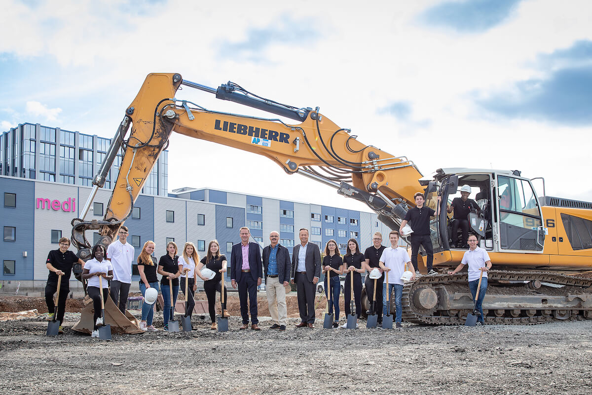 ße Baumaschinen haben das Gelände in den letzten Monaten für den Medi Neubau vorbereitet. Jetzt weihten die neuen Auszubildenden gemeinsam mit der Geschäftsführung (Bildmitte v.l.: Gerhard Kolb, Stefan Weihermüller und Dirk Treiber) die Baustelle ein. (Foto: Medi)