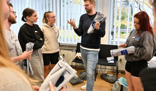 Die Rahm-Auszubildenden verfolgen, was ihnen Trainer Mattis Hohmann von der Bauerfeind-Akademie zum Thema Kniebandagen erklärt. (Foto: Bauerfeind)