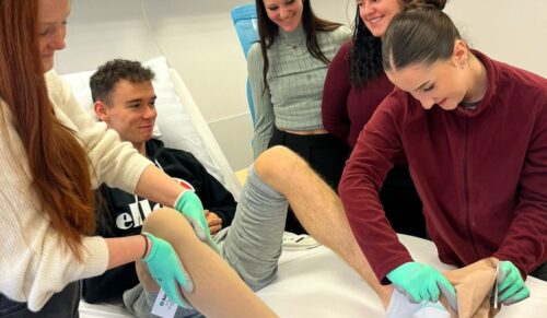 Pflegeschülerinnen und -schüler legen Kompressionsstrümpfe am Beispielpatienten an.  (Foto: Juzo)