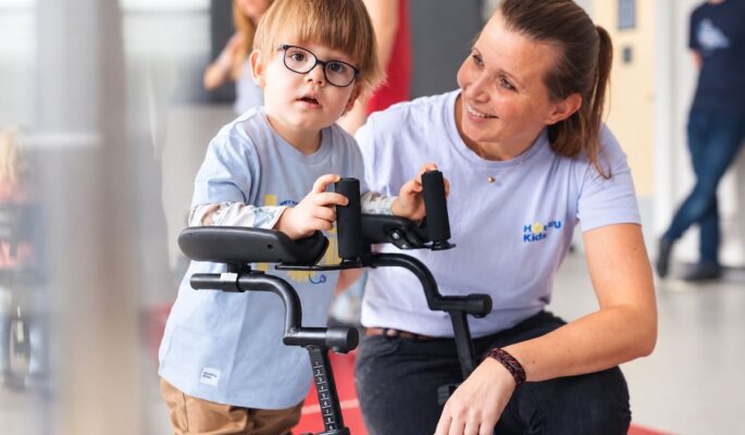Kampagnenmotiv „rehaKIND Kompetenzprogramm Hilfsmittel“. (Foto: rehaKIND/VitalCentrum HODEY KG, KI-bearbeitet)